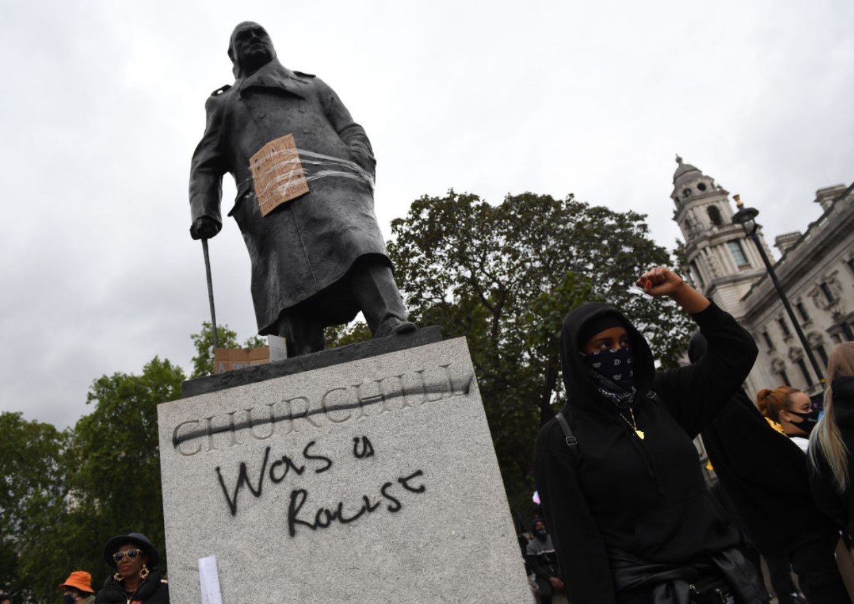 Statue of Winston Churchill, which has graffiti with the words "was a racist" outside the Houses of Parliament in Westminster during a Black Lives Matter protest