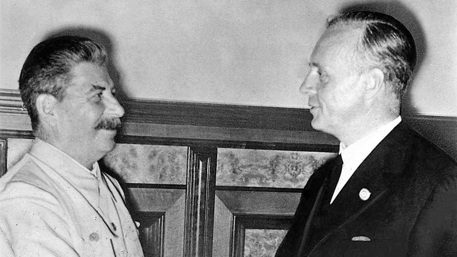 Black and white photo of Joseph Stalin and Joachim von Ribbentrop after signing the Nazi-Soviet pact.