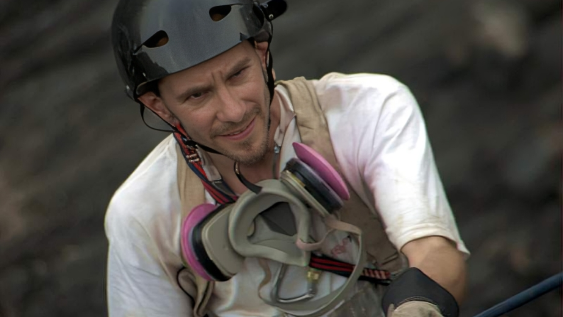 George Kourounis wearing a helmet on his head and a gas mask around his neck.