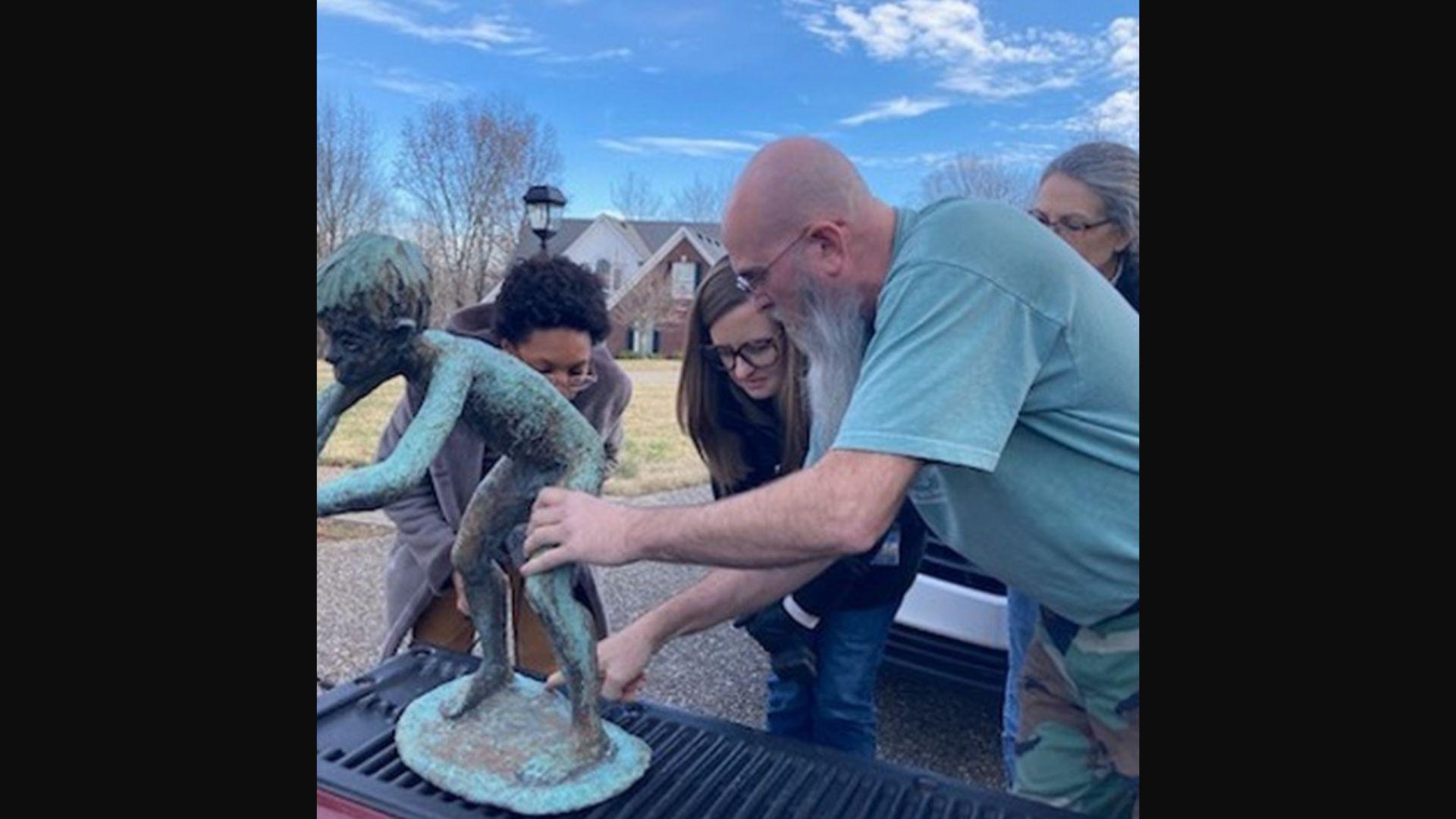 David Greer and members of the Louisville Metro Public Art loading the Pan statue in the back of a truck