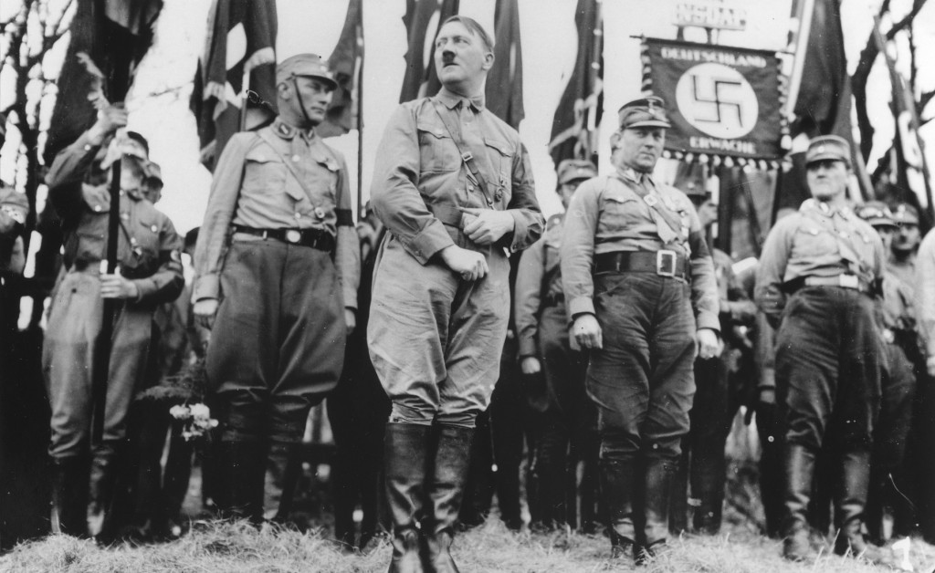 A grayscale image of a the Nazi party standing on top of a hill