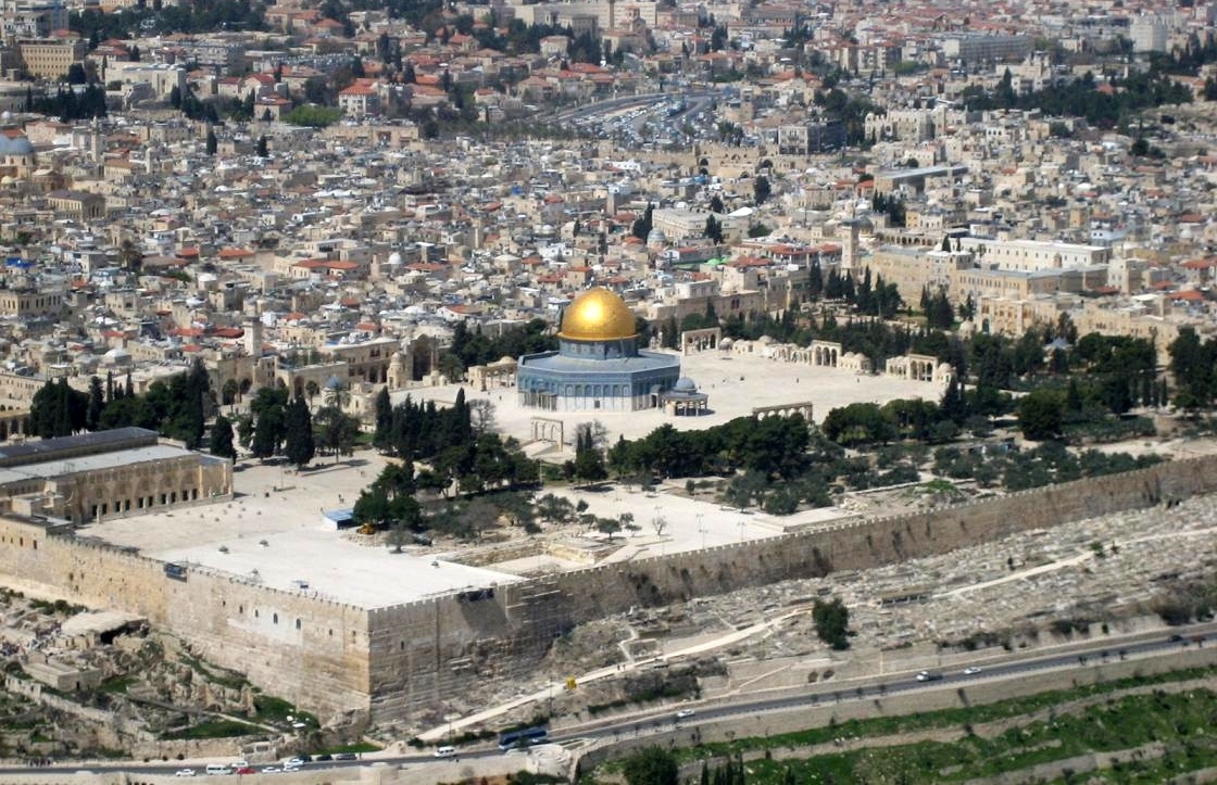 A temple with a gold dome in the middle o fa crowded city