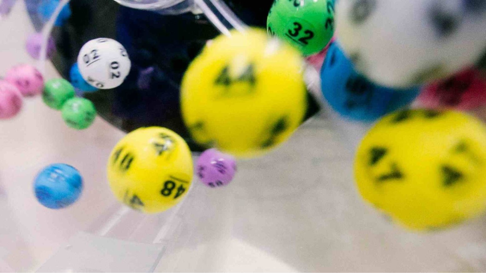 A group of lottery balls tumbling in a container.