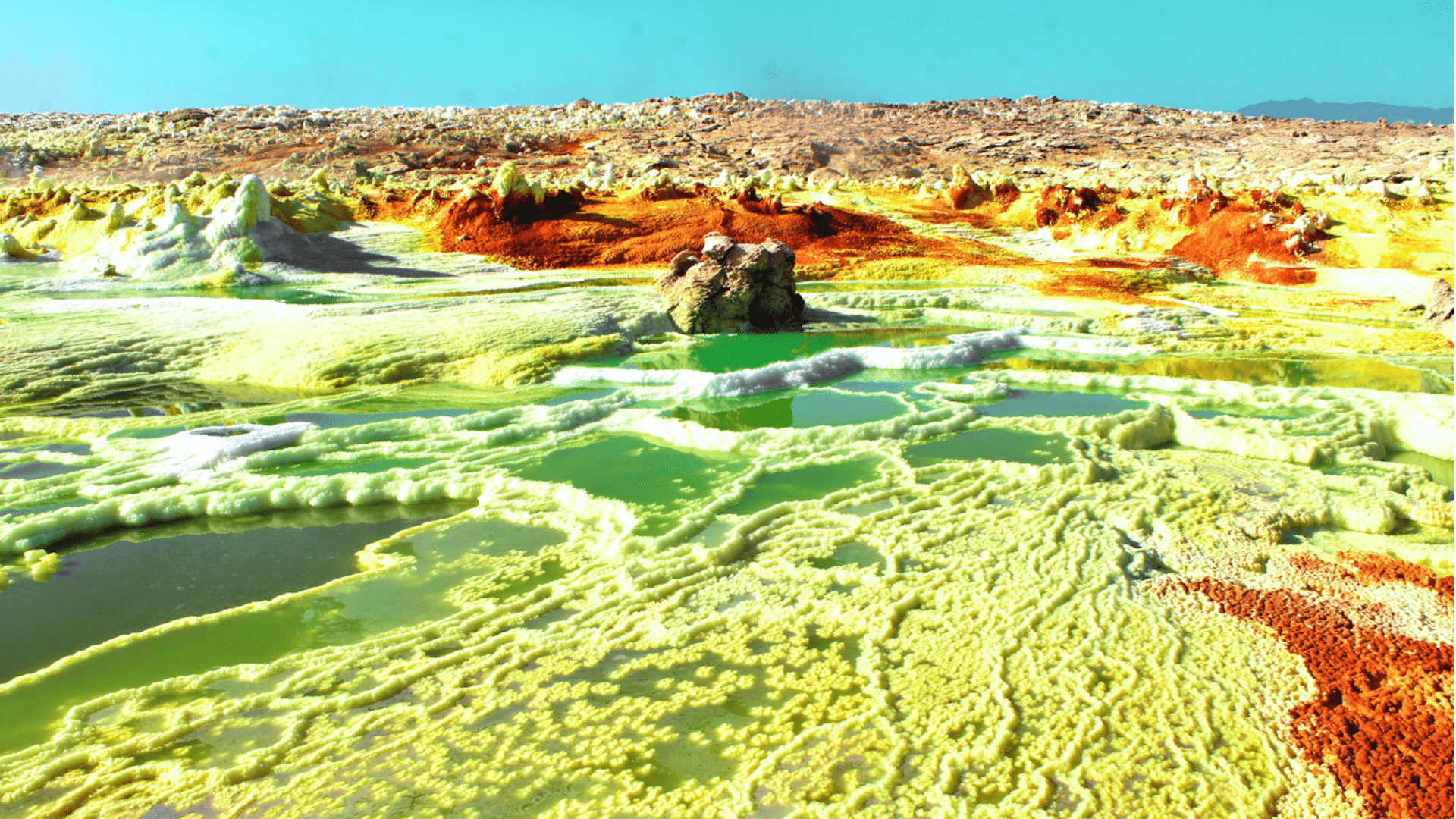 Hydrothermal chimneys, salt pillars and terraces of Dallol, Ethiopia. The landscape is multi-colored and semi-psychedelic.