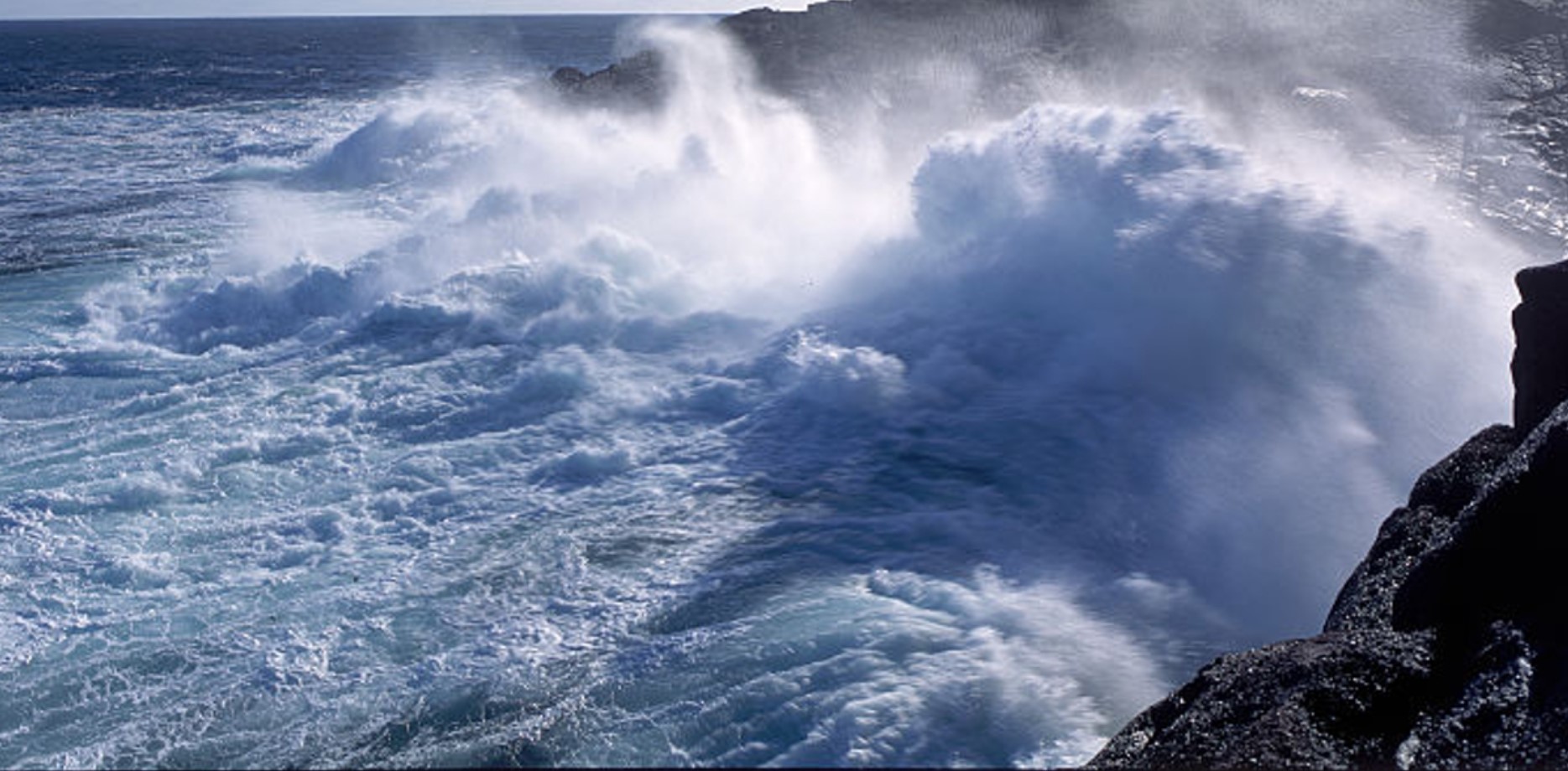 Waves crash onto the rocky shores of Cape Spear, Newfoundland, Canada