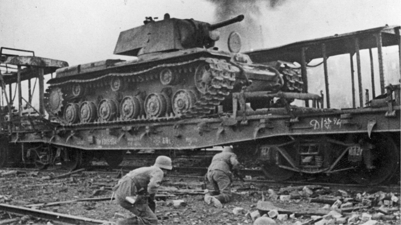 Black and white photo of troops hiding behind a Soviet Union tank during a confrontation with German army during World War II.