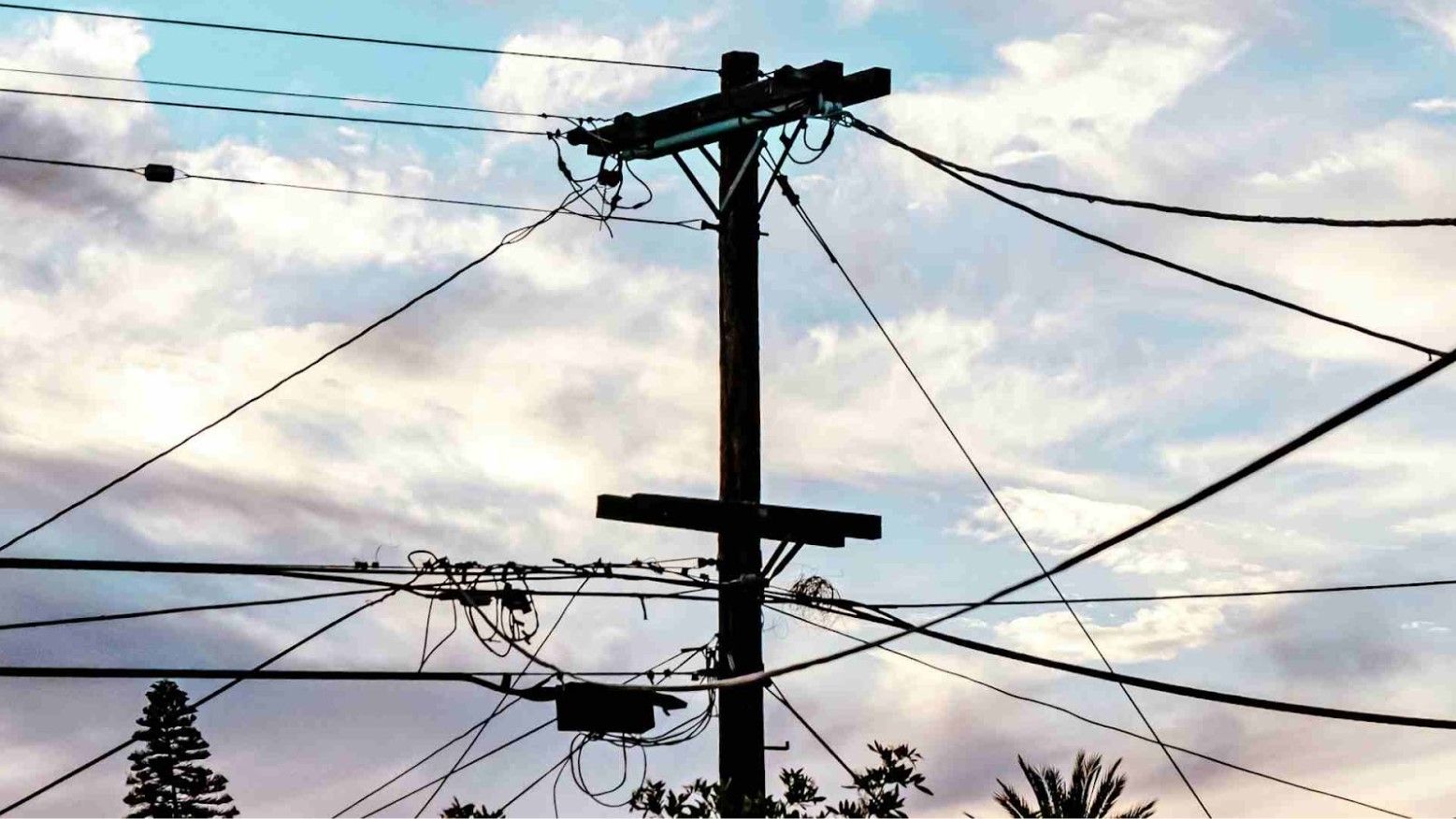 A telephone poll silhouetted by a colorful sky.