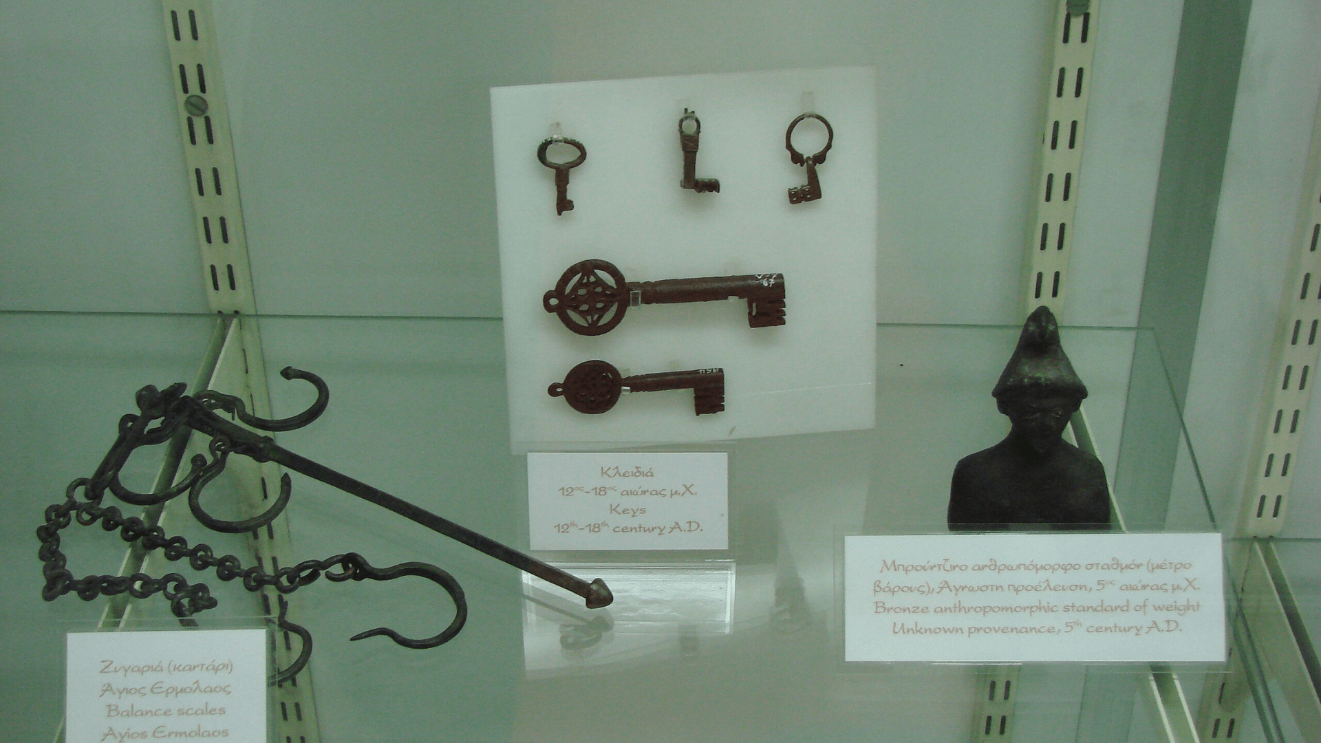 A medieval balance scale, keys, and a standard of weight.