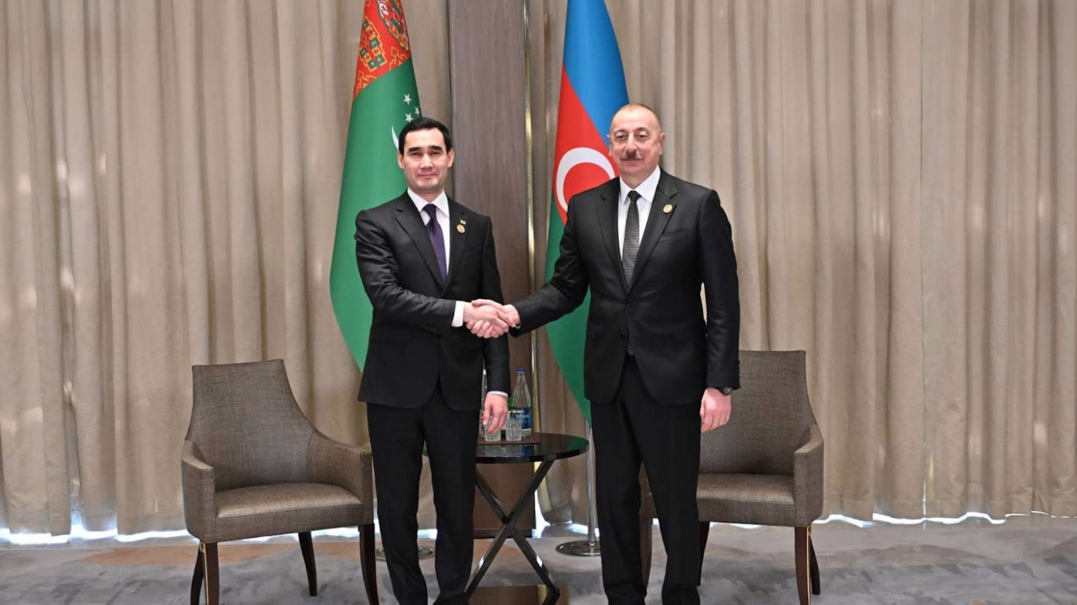 Serdar Berdimuhamedov shakes hands with his father.