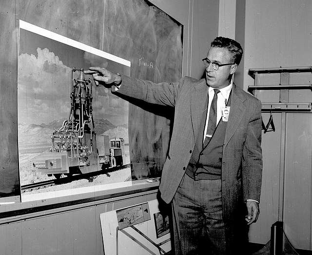 Raemer Schreiber pointing at a chart on a blackboard for the Manhattan Project