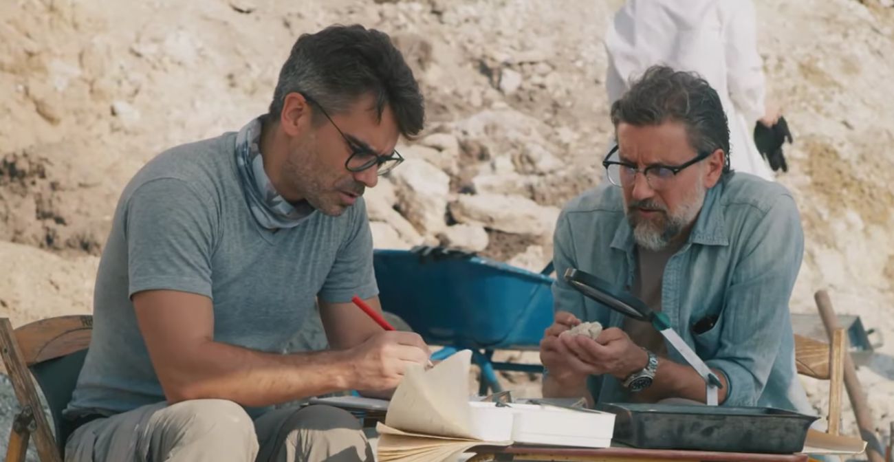 Two archaeologists go over notes on site