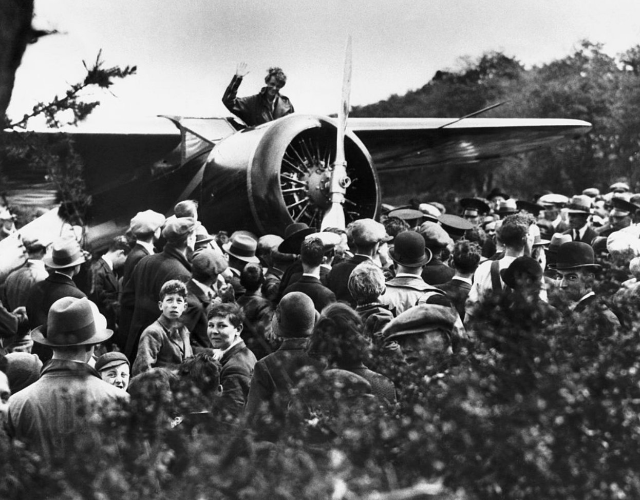 Amelia Earhart Putnam, waving to admiring crowd after her arrival at Londonderry, Ireland