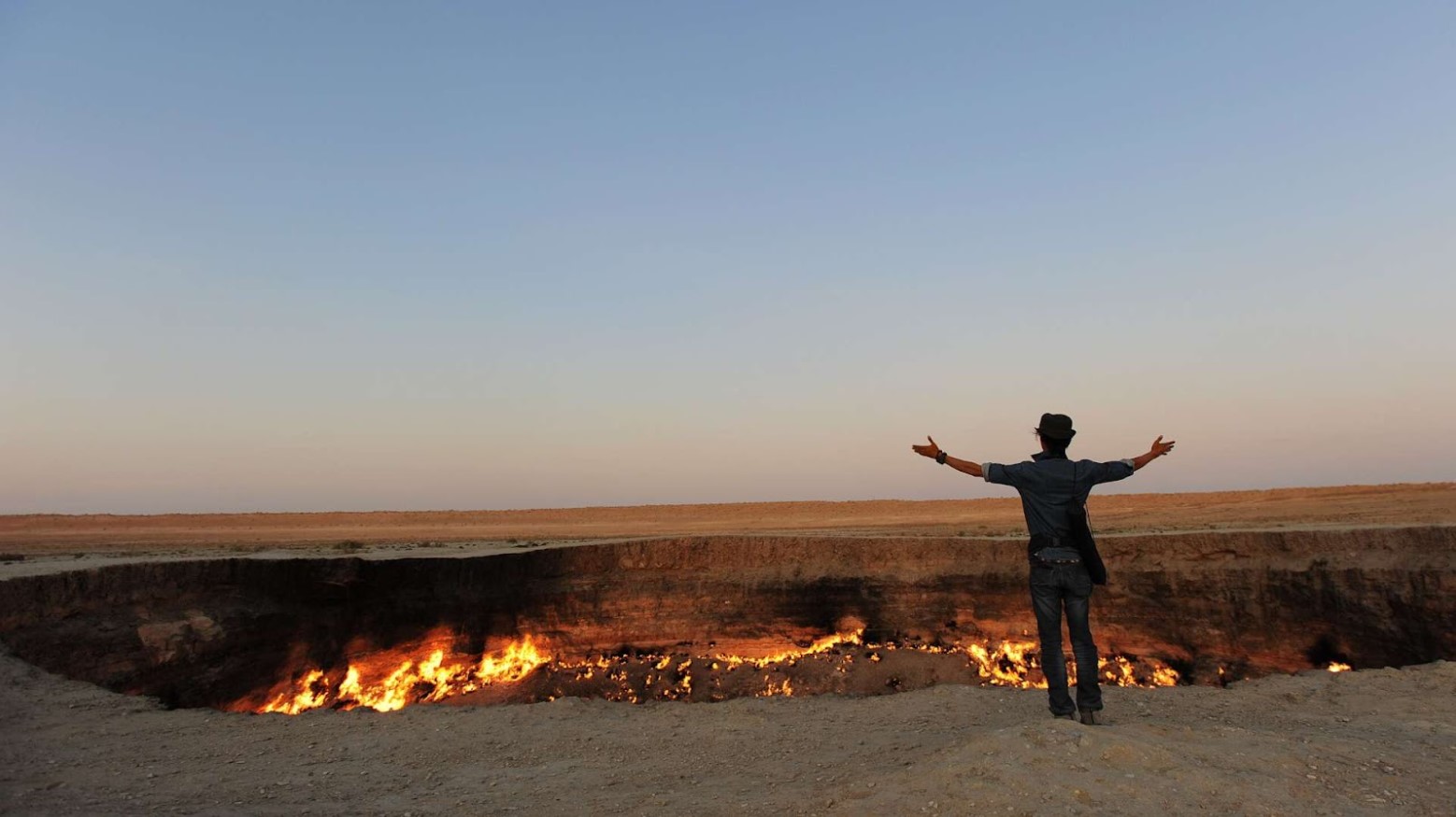 A man holding his arms open to the Gates of Hell.