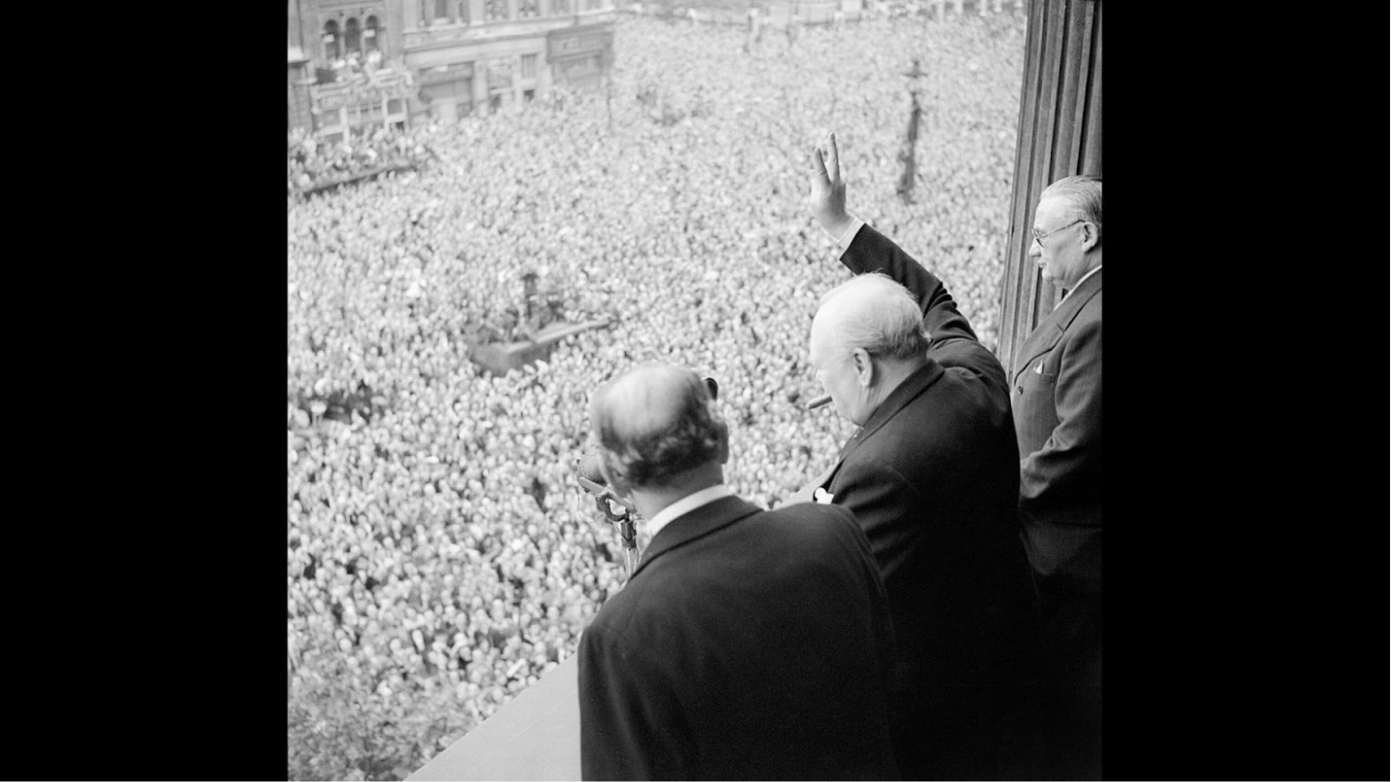 Winston Churchill waves to crowds in Whitehall in London as they celebrate VE Day, 8 May 1945