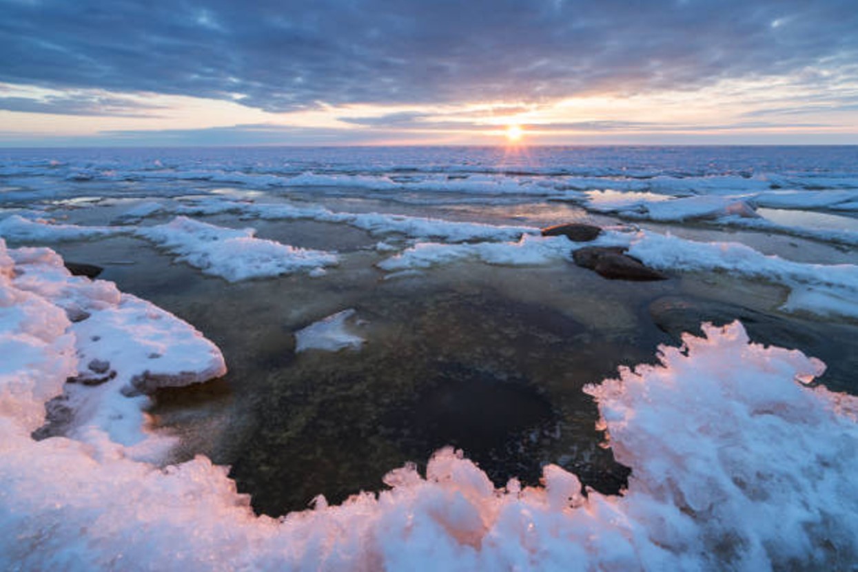 View of the Baltic Sea during sunset in the winter when ice covers part of the surface