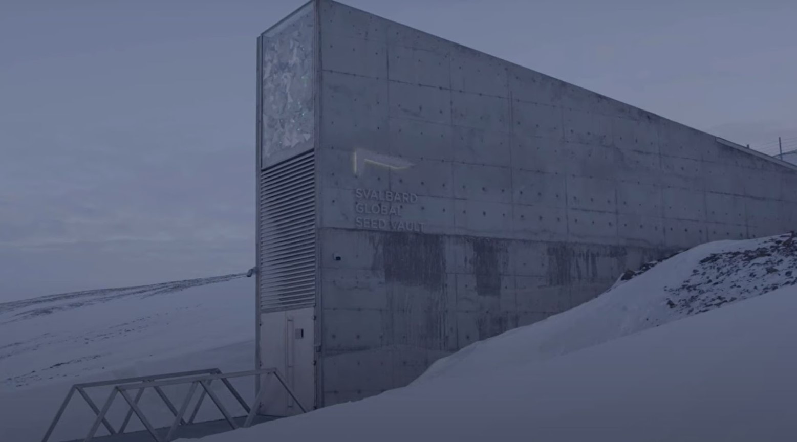 The seed vault in Norway. It is surrounded by snow and has a bridge leading up to it.