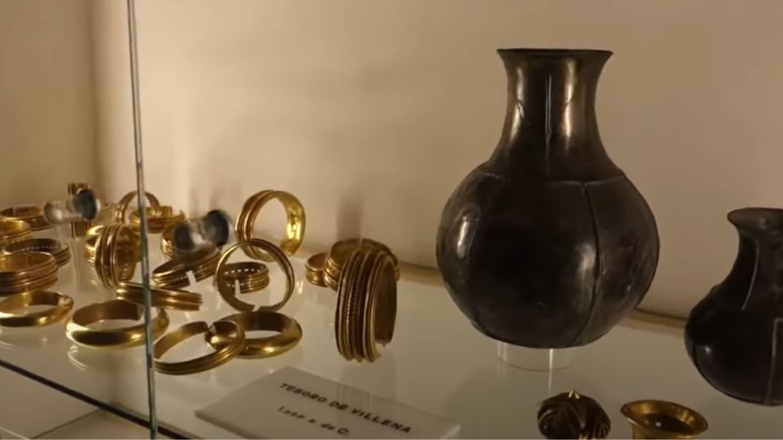 A display of the Treasure of Villena in the Museum of Villena. On this shelf, there are some vases and gold bracelets.
