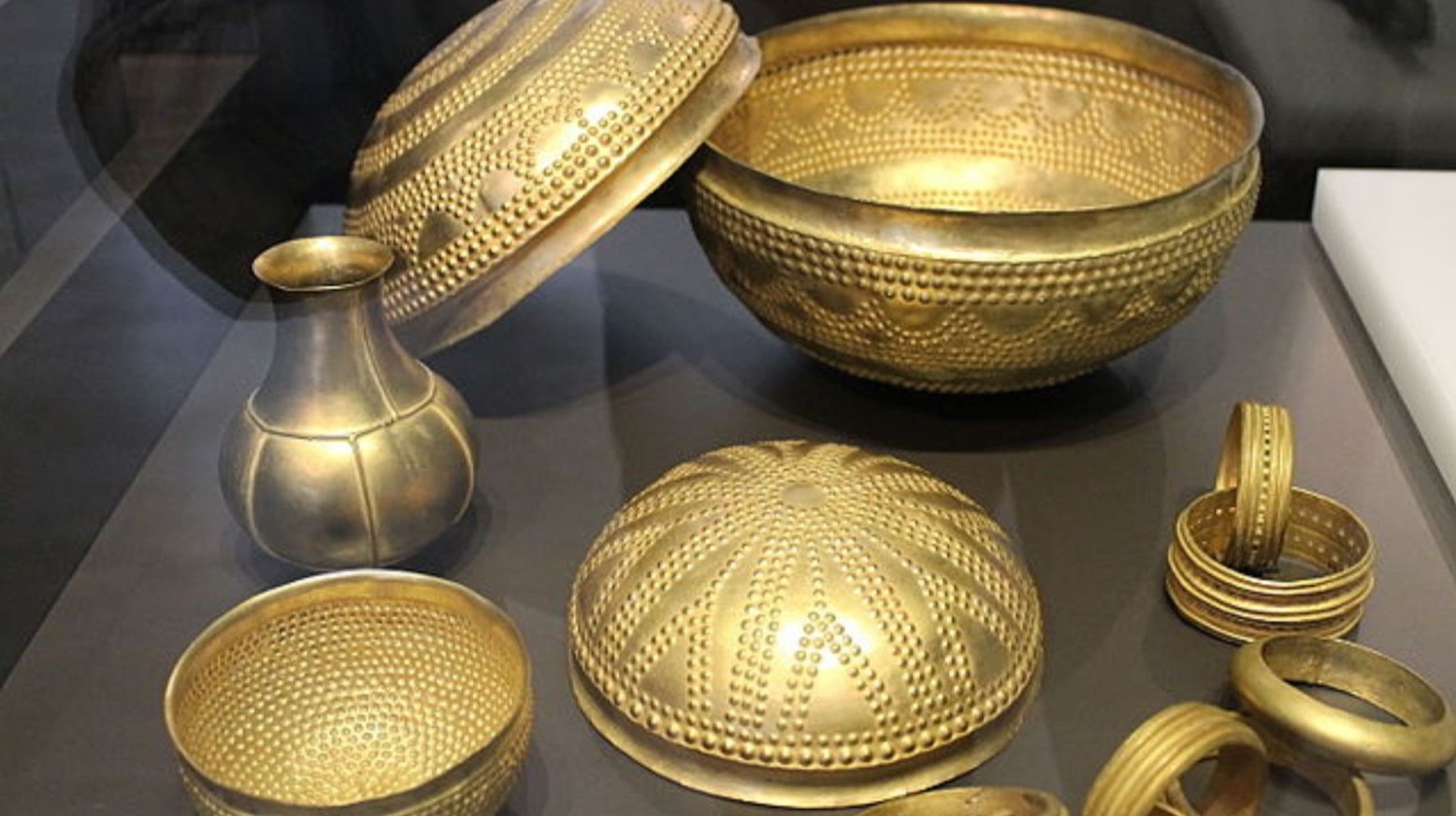 Some pieces from the Treasure of Villena. There are four bowls, a vase, and some bracelets. All of the items are gold.