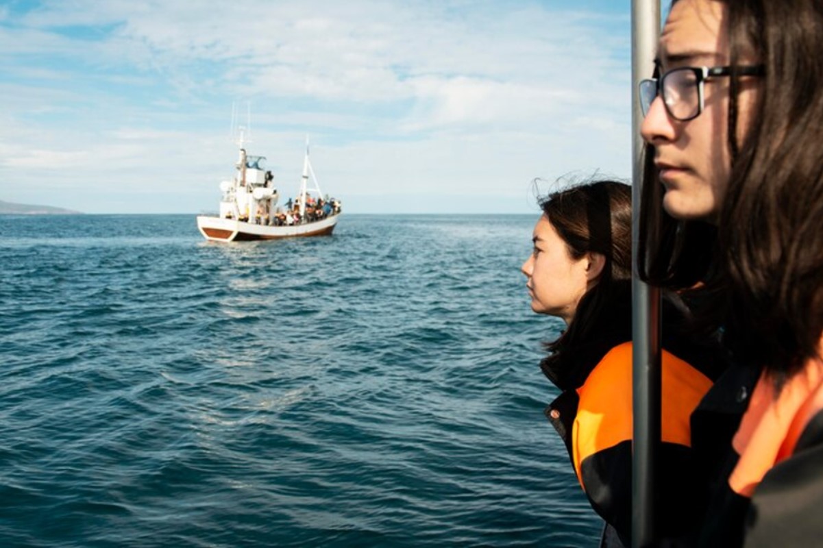An image of two children looking out to sea aboard a coast guard vessel