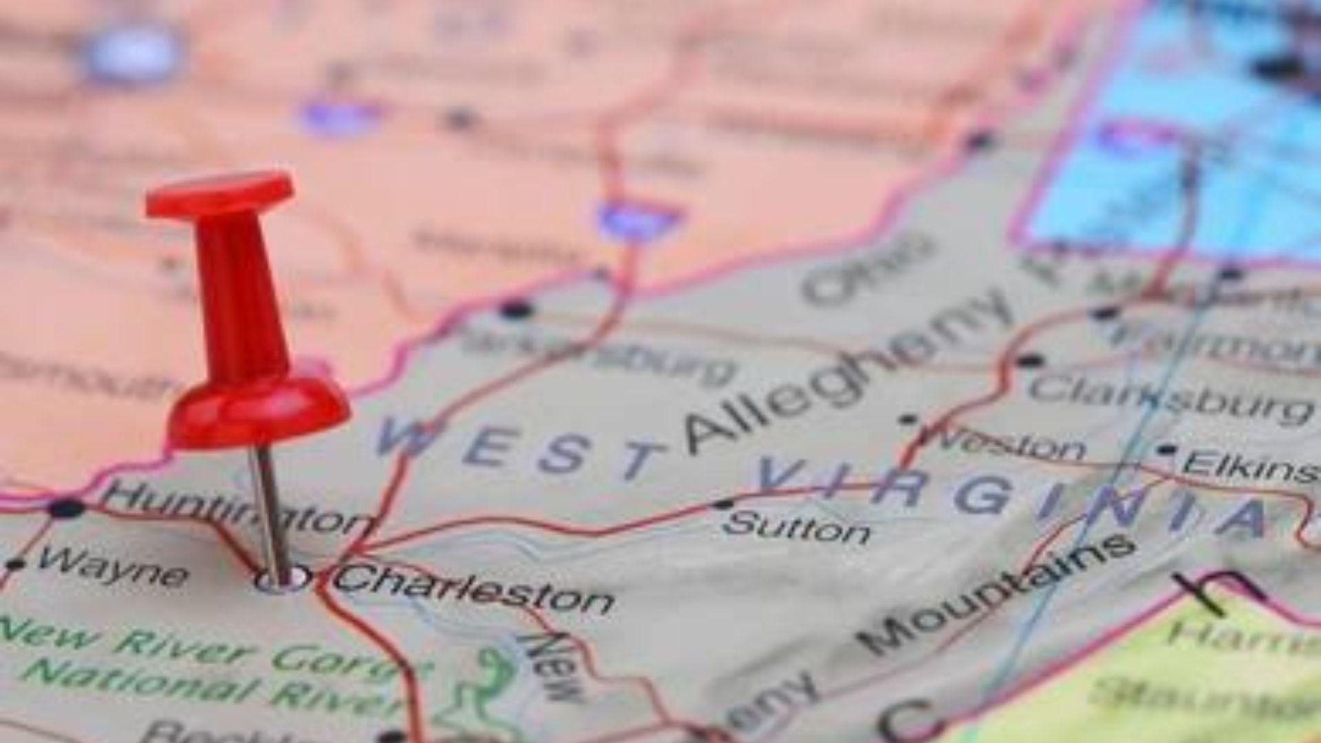 Close-up photograph of a map of West Virginia with a red pin in Charleston