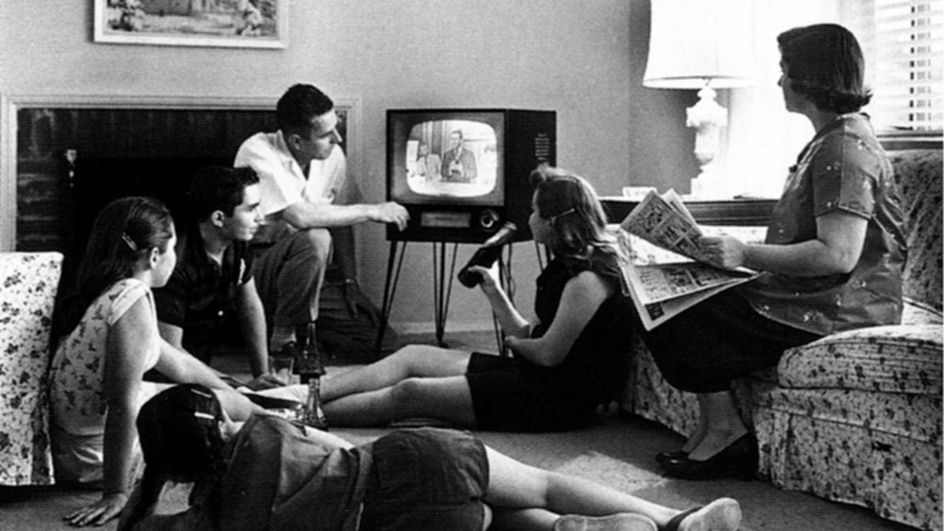Black and white photograph of a family watching TV in 1958