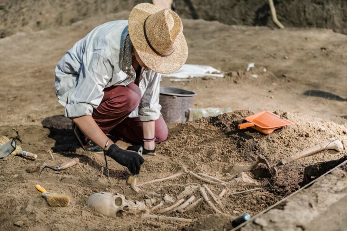 An archaeologist pictured in a shirt and hat during an excavation