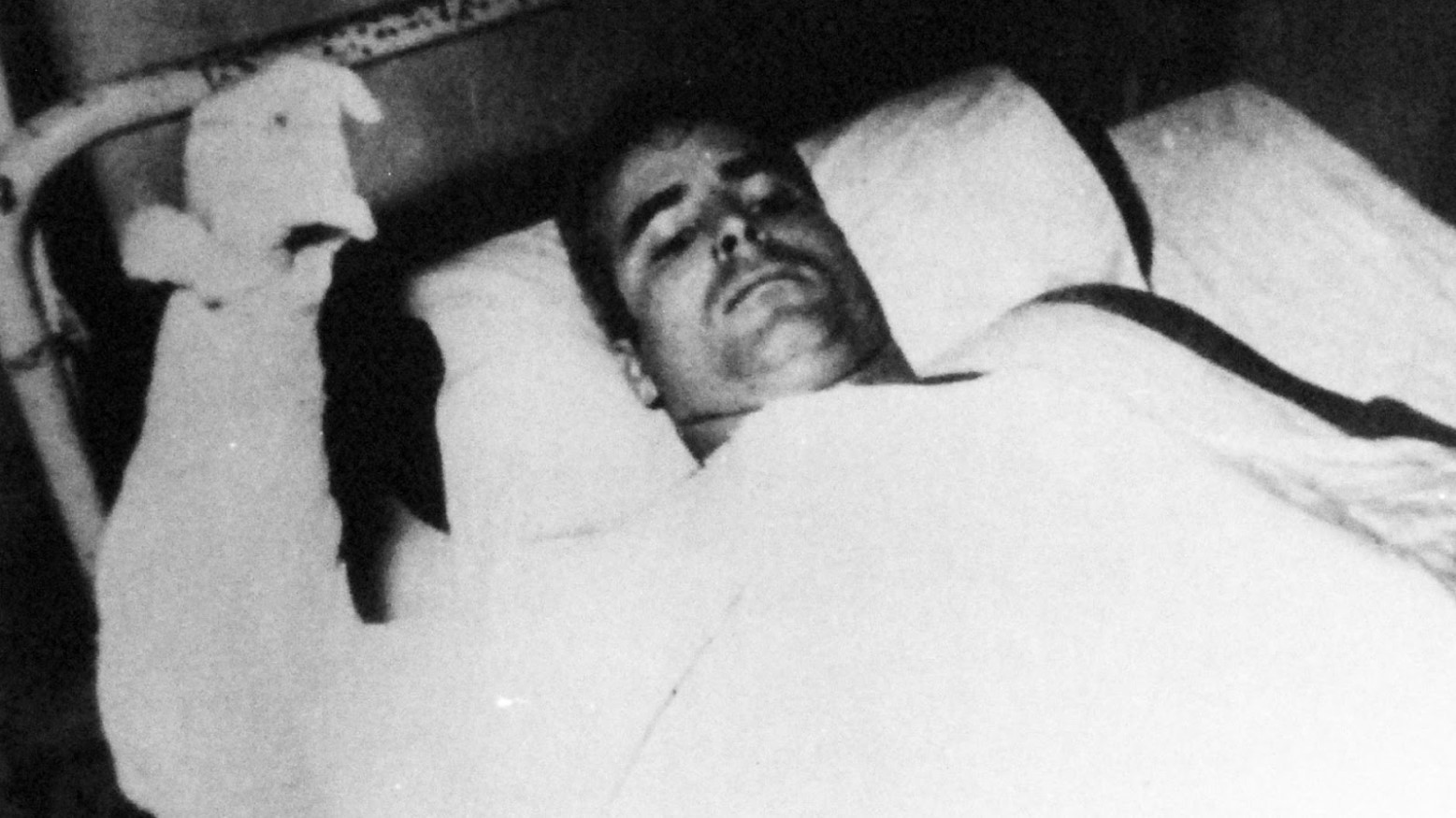A black and white photo of John McCain in a hospital bed after being a POW during the Vietnam War.