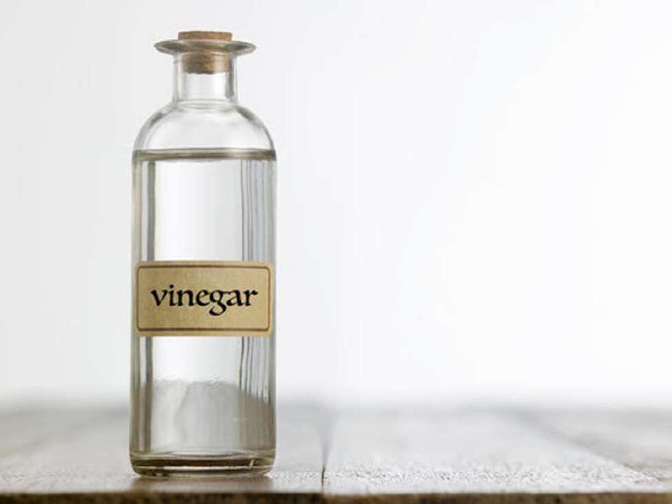 Glass bottle of vinegar on a wooden table