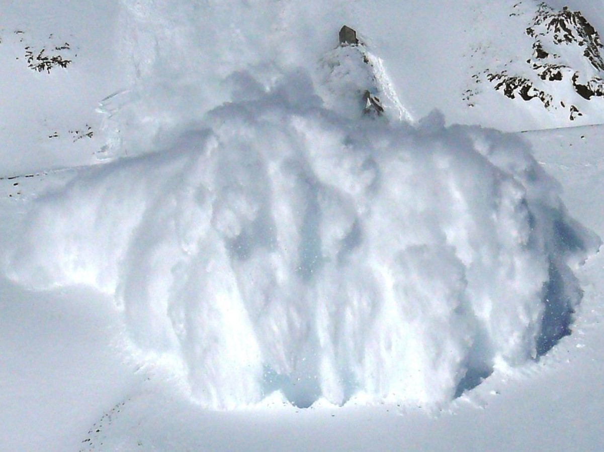 A large avalanche is pictured as snow rolls down a mountainside