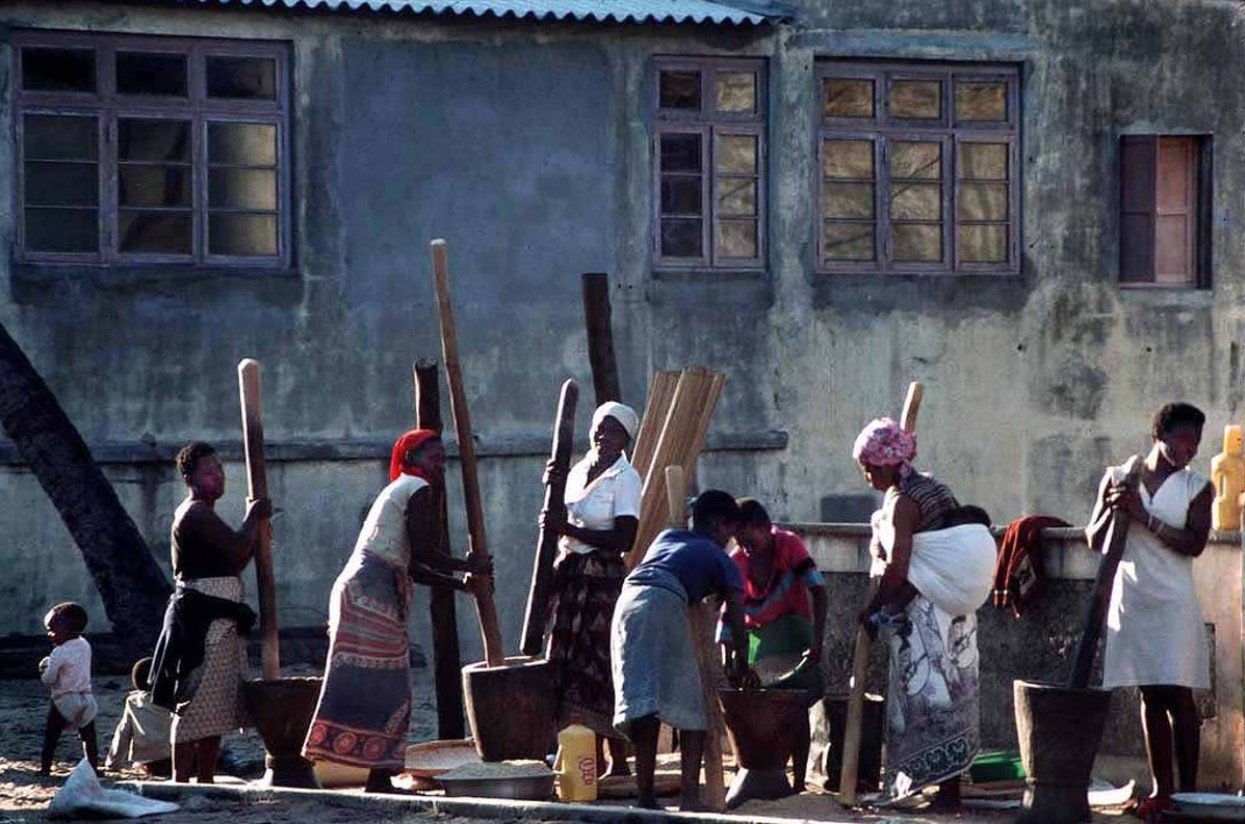 Group of Mozambican women husking rice