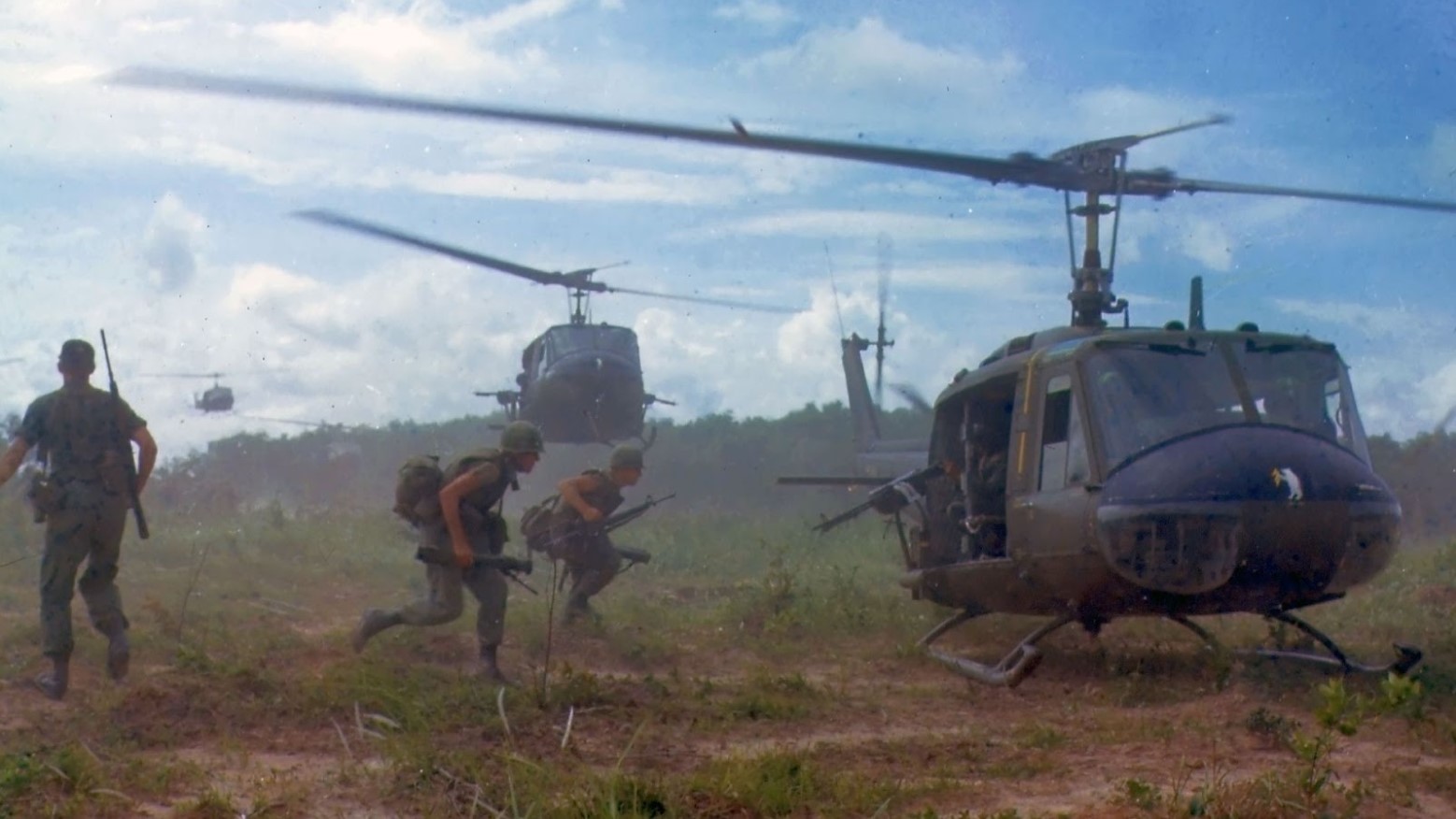 U.S. soldiers running to a helicopter during the Vietnam War.