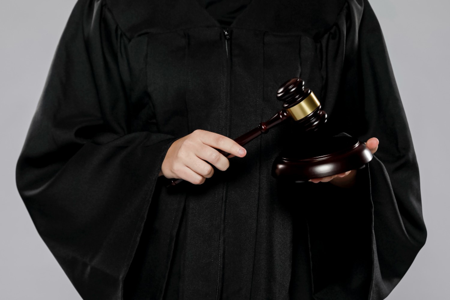 A judge is pictured holding a hammer in her hand dressed in a black robe