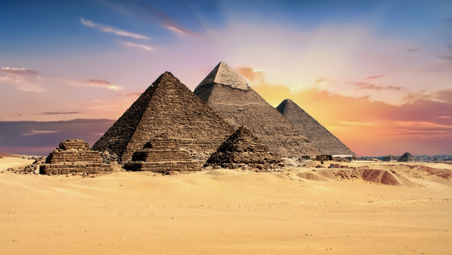 A photograph of the sun rising behind the Pyramids of Giza in Egypt