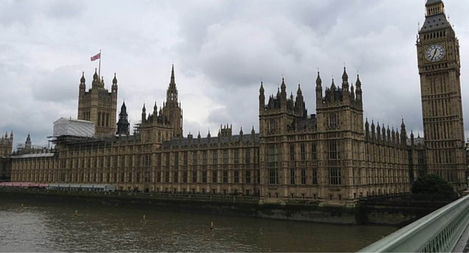 Westminster and Big Ben, where the Houses of Parliament are in the UK. The building is next to the River Thames, which looks like muddy water.