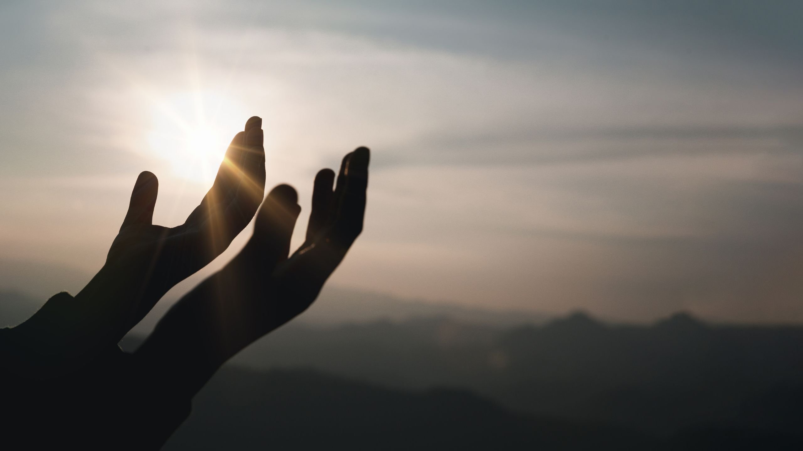 Hands lifted to heaven outside