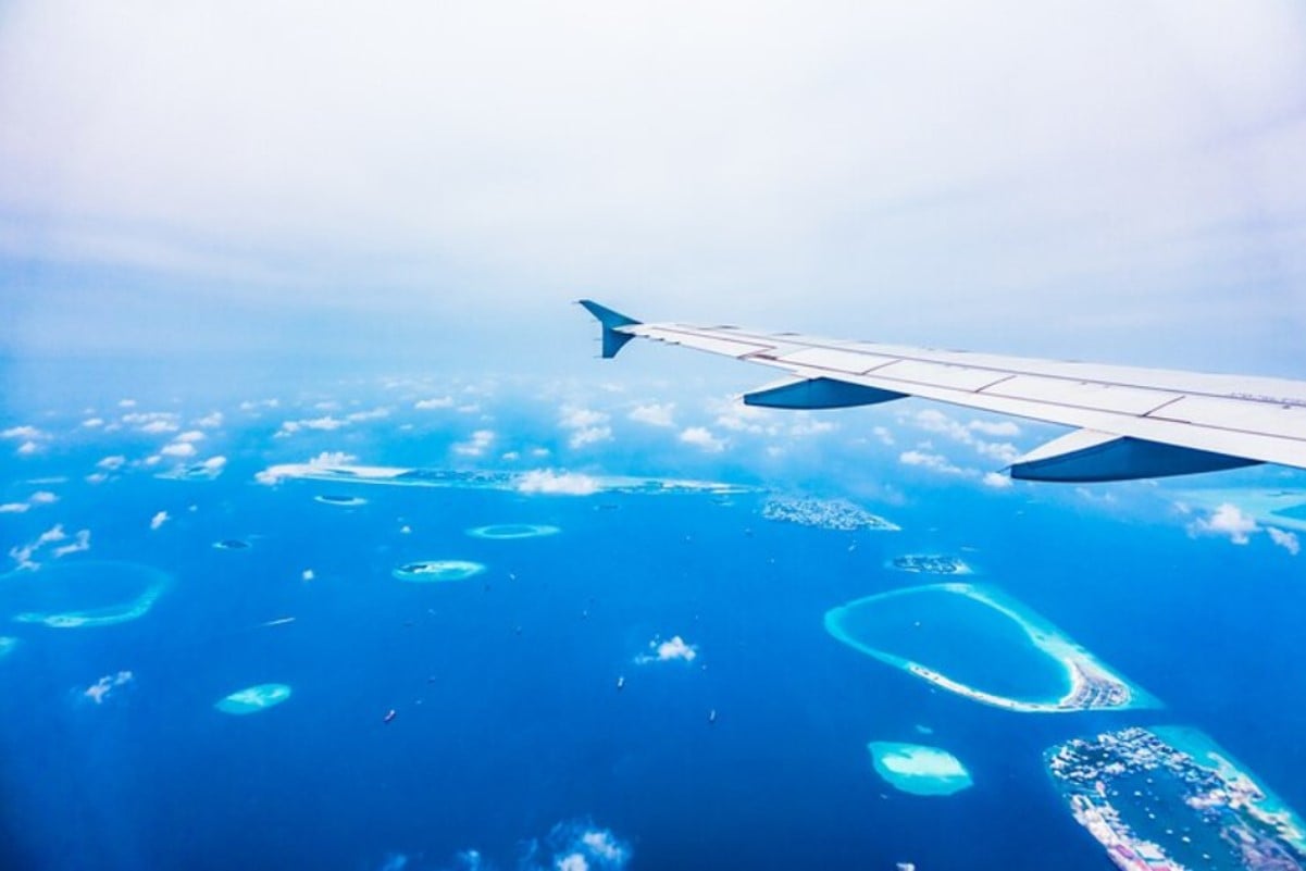 An image of a large passenger jet flying over the ocean