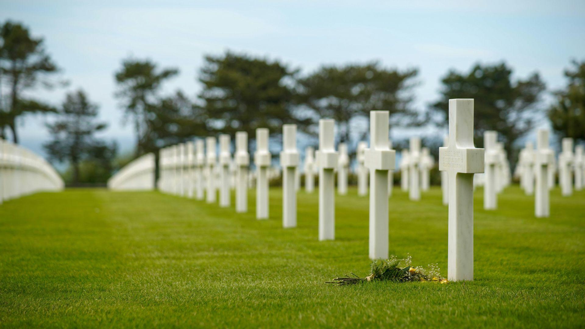 The cemetery in Normandy dedicated to the American soldiers who died during D-Day, with many white crosses in green grass.