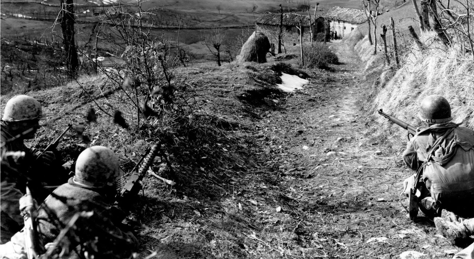 U.S. Army soldiers during WWII securing a road in Europe.