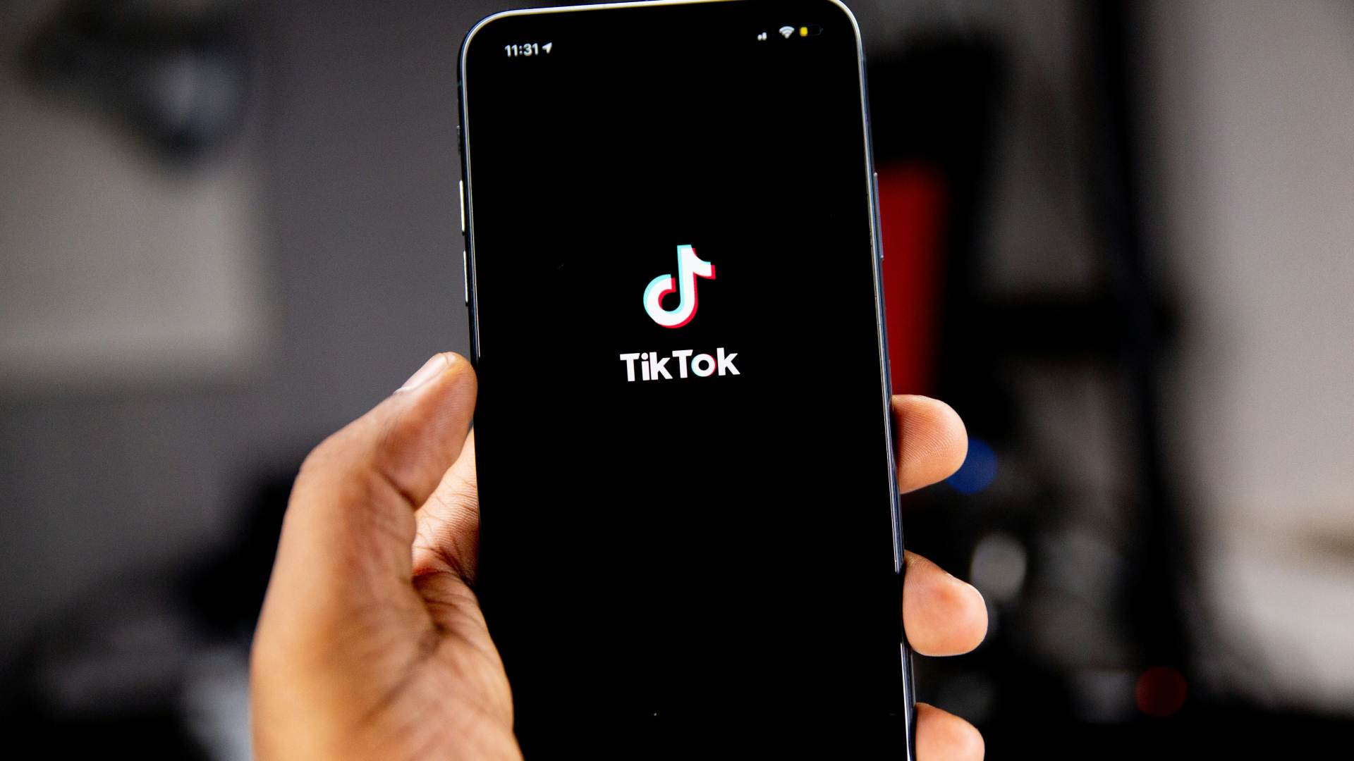 A person opens the TikTok app on their phone.