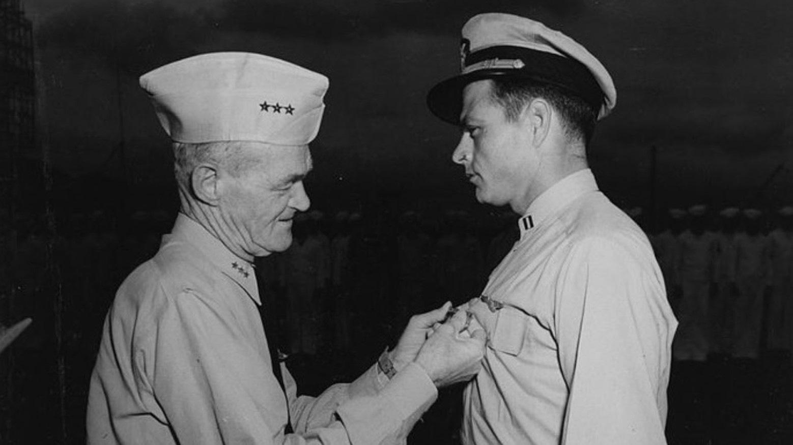 A man putting a medal on another soldier during World War II.