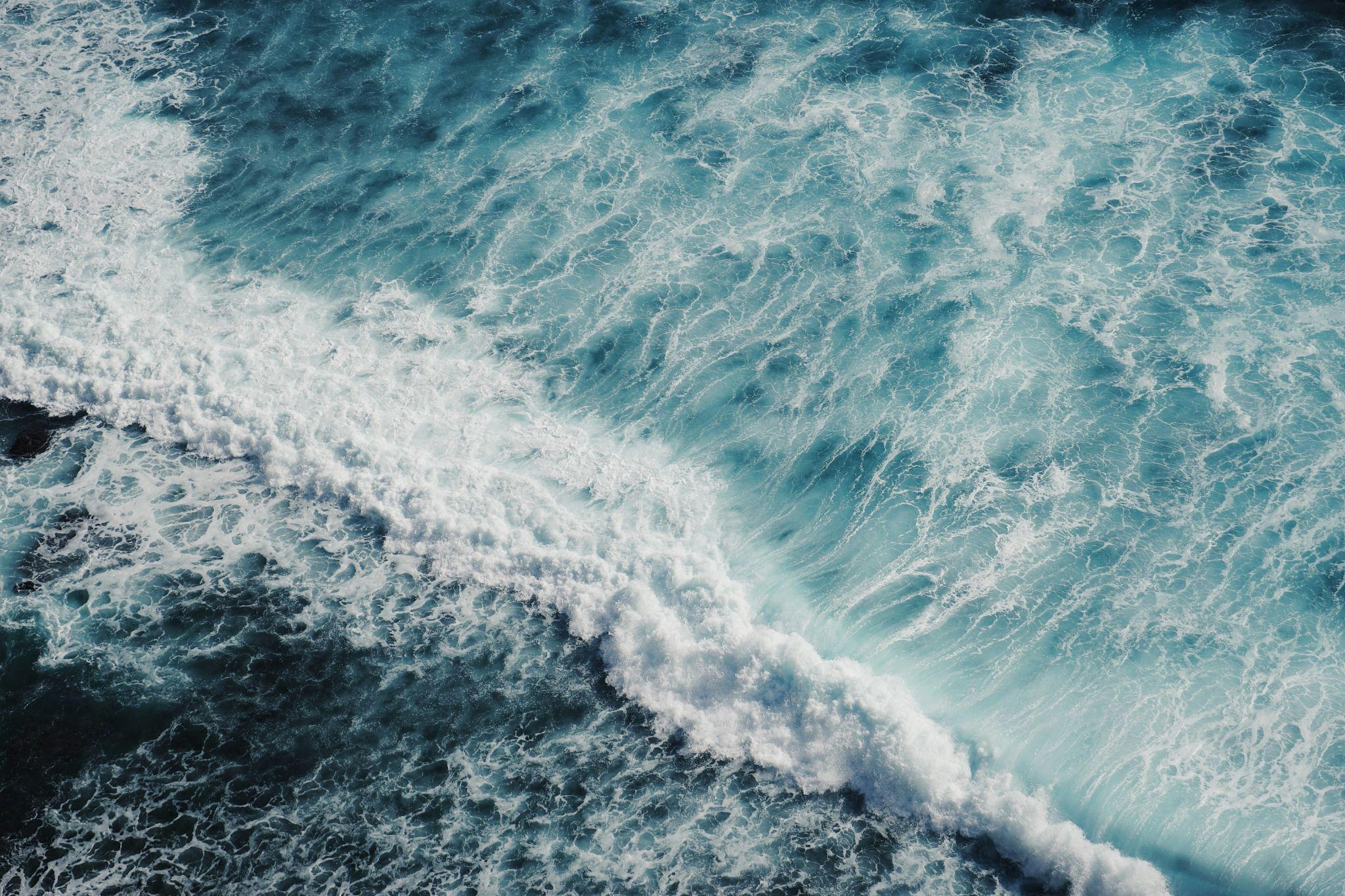 An aerial view of light and dark blue ocean waves.