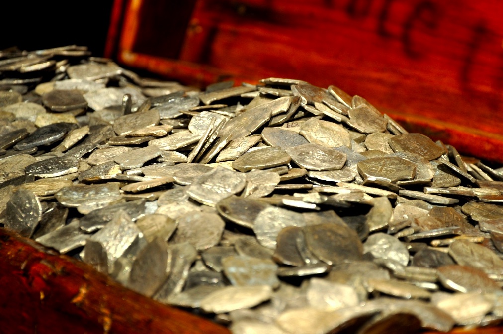 A red velvet lined treasure chest with gold coins