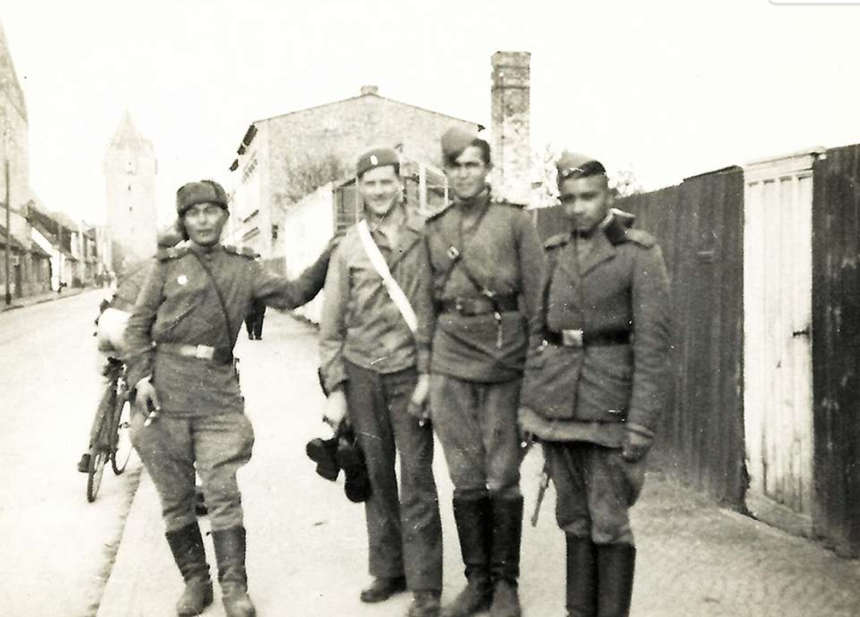 Several soldiers stand on the road during WWII