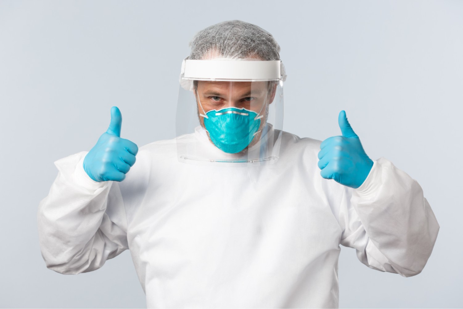 A man is pictured in full protective clothing, wearing gloves and a facemask