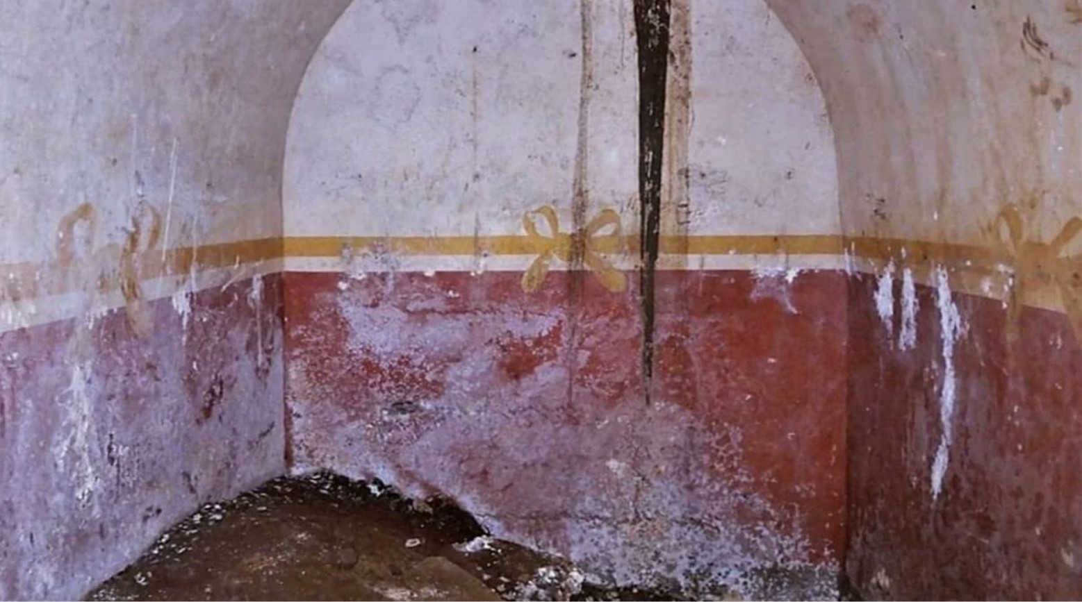 The tomb that was discovered during sewage construction. It is white and red with a gold ribbon and bow around the center.