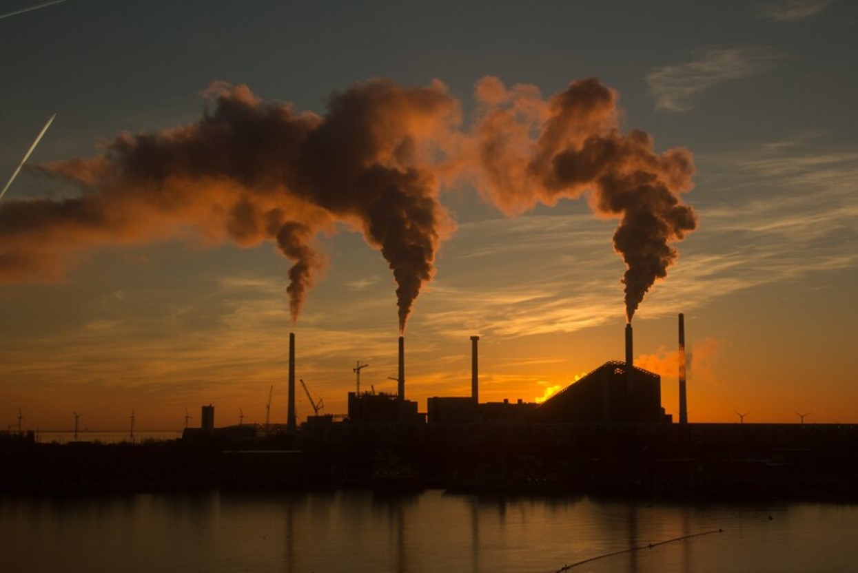 Fossil fuel emissions from a factory at sunset