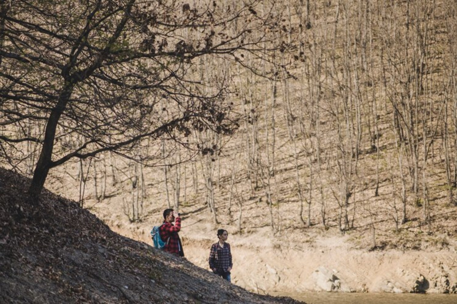 An image of a man and a woman hiking along a trail