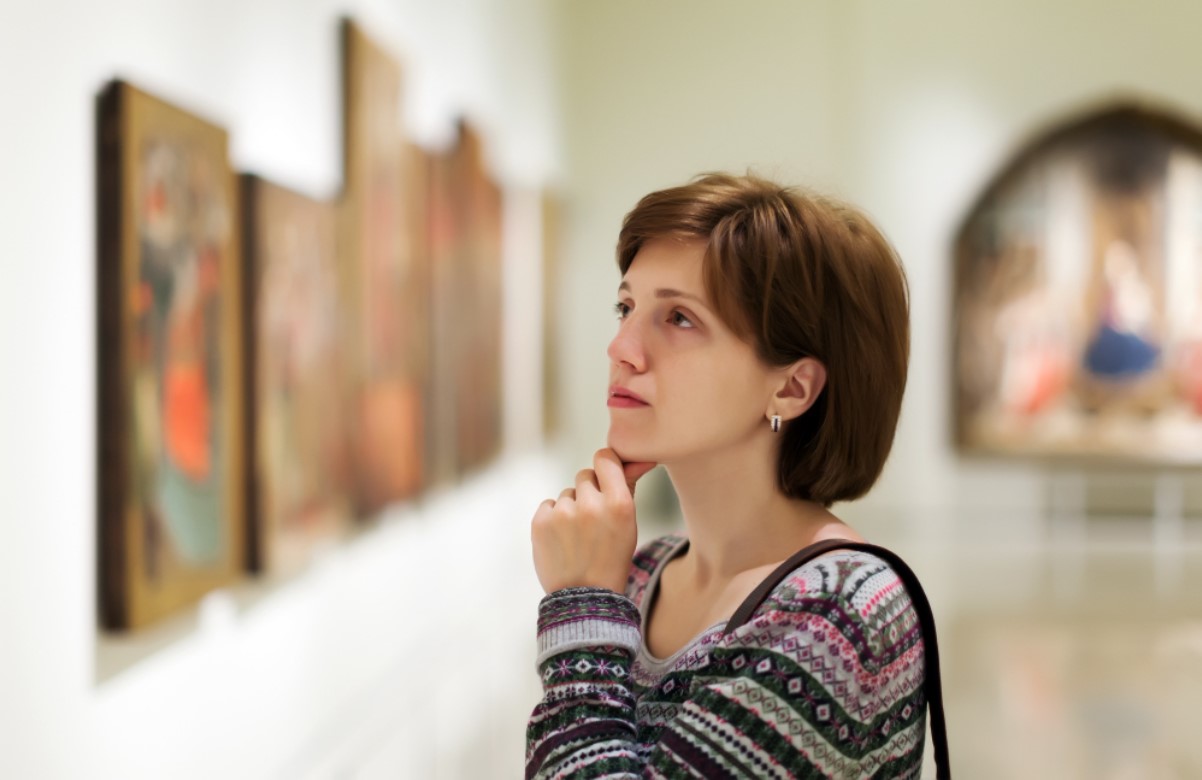 An image of a woman admiring a painting in a museum