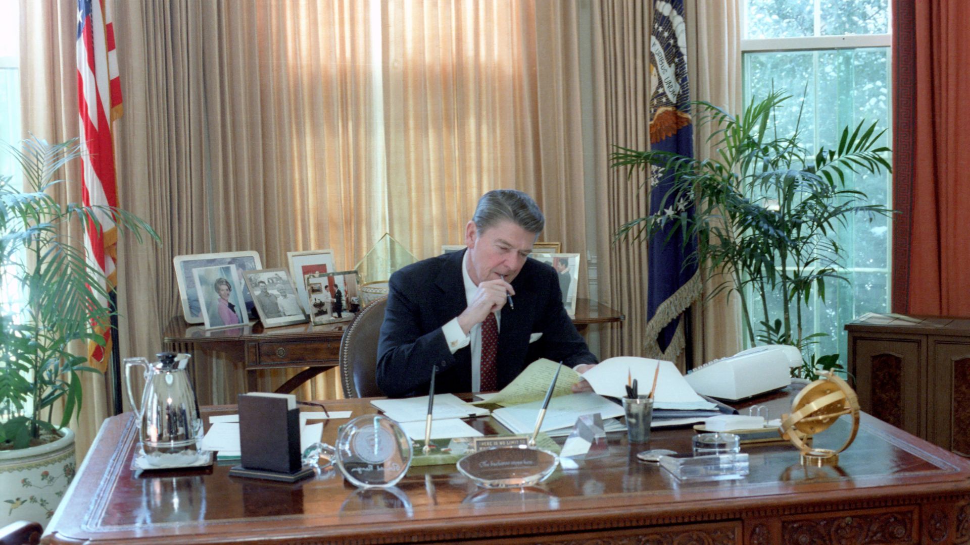 Ronald Reagan in the Oval Office in the White House working on paperwork in 1982.