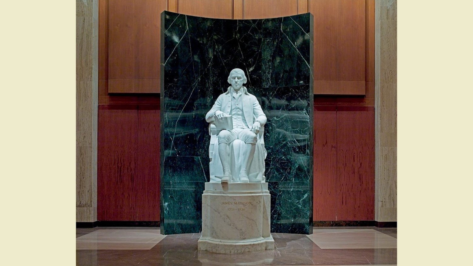A white marble statue of a James Madison, Father of the Constitution, in a room